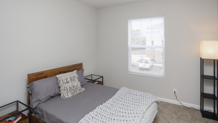 a bedroom with a bed, a nightstand, and a window at The Alpine Studios