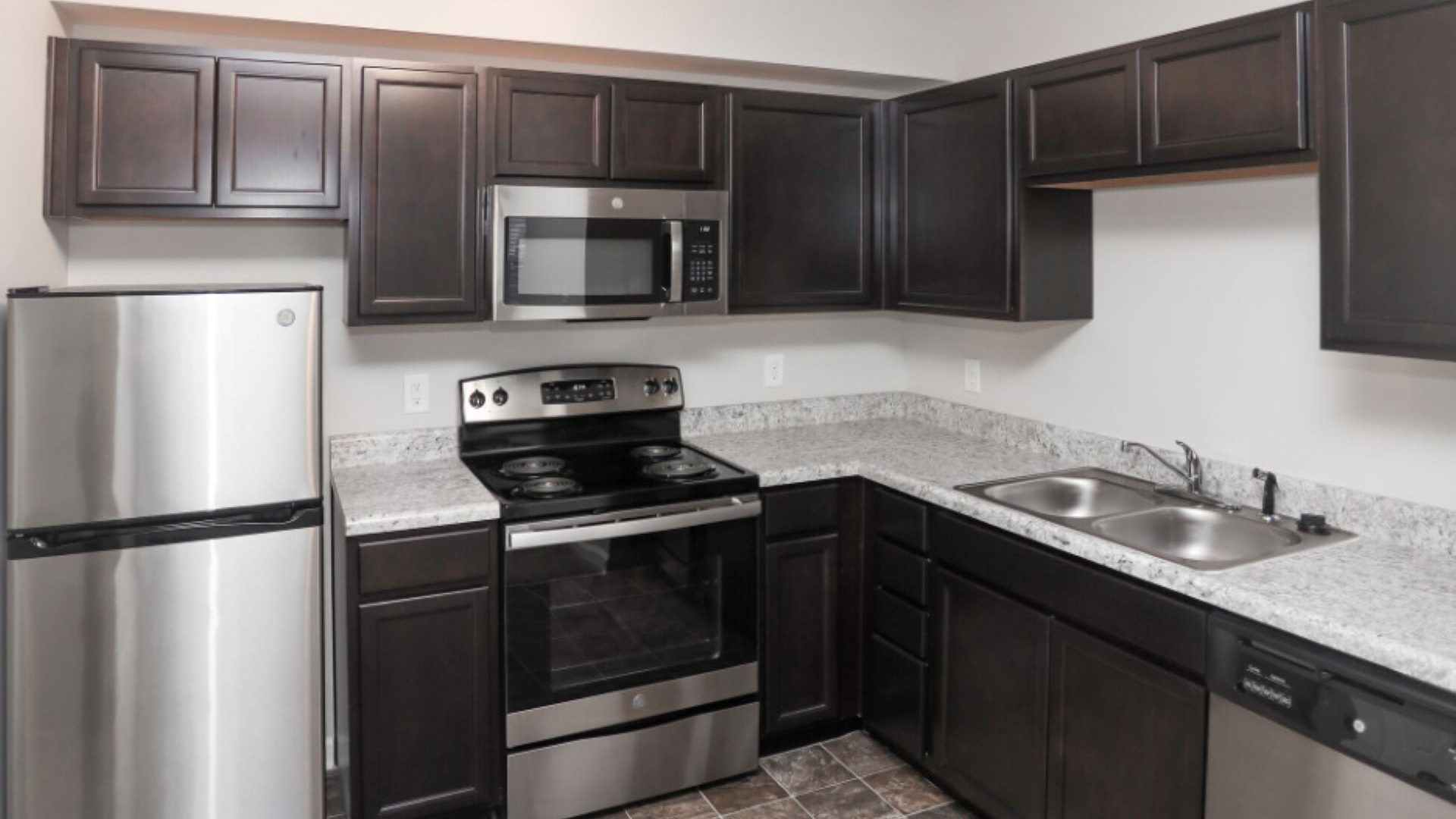 a kitchen with stainless steel appliances and black cabinets at The Alpine Studios